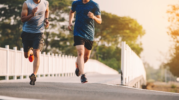 Young people runner running on running road in city park