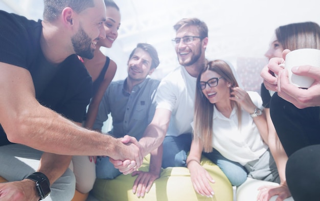 Foto i giovani si stringono la mano in una cerchia di amici