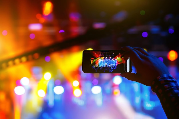 Young people shoot photo or video of a concert on smartphone