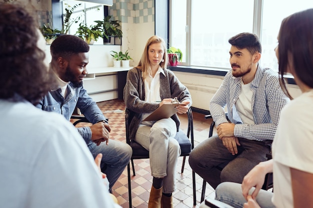 Young people sitting in a circle and having a discussion