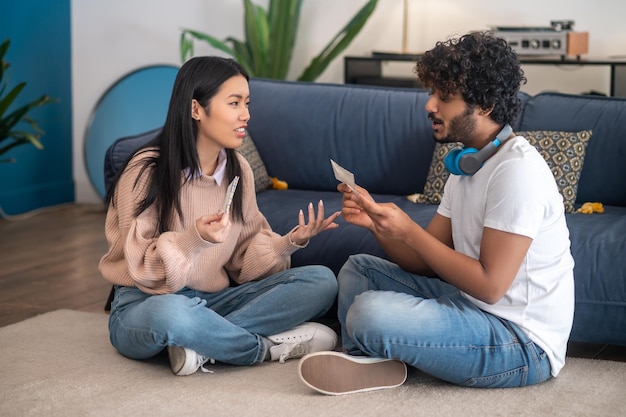 Photo young people sitting on the floor with envelopes in hands