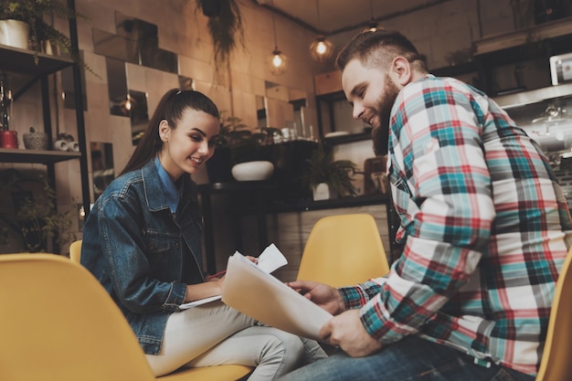 Young people studying documents while in a cafe