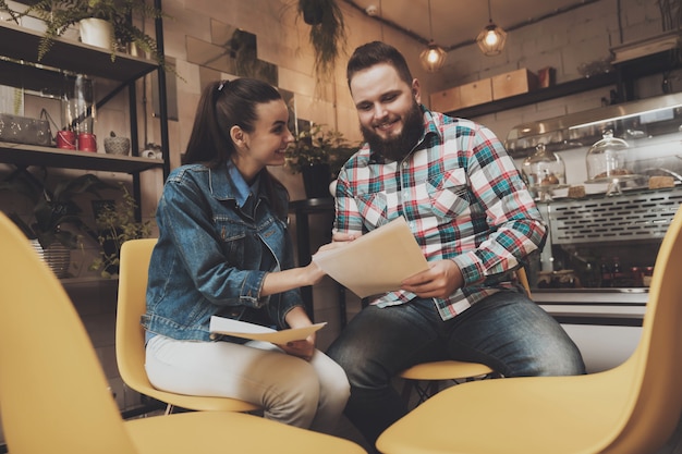 Young people studying documents while in a cafe