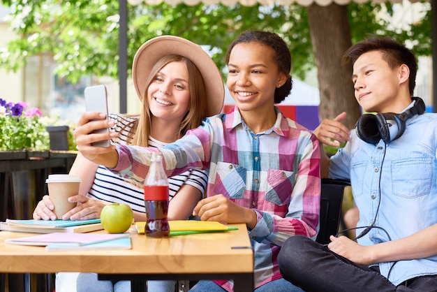 Giovani che prendono selfie in caffè