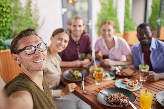 Foto giovani che prendono la foto di selfie in caffè