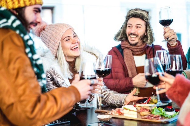 Young people toasting red wine at restaurant patio