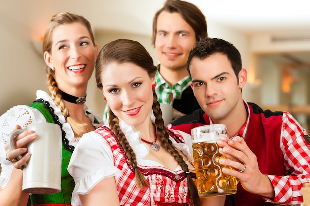 Photo young people in traditional bavarian tracht in restaurant or pub