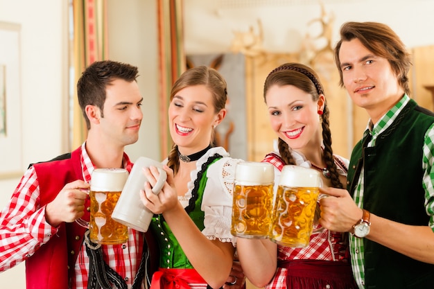 Photo young people in traditional bavarian tracht in restaurant or pub