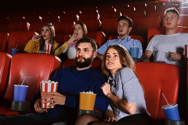 映画館で映画を見ている若者