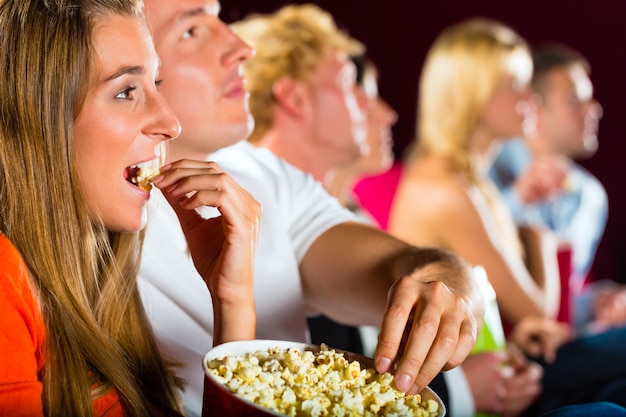 映画館で映画を見ている若者