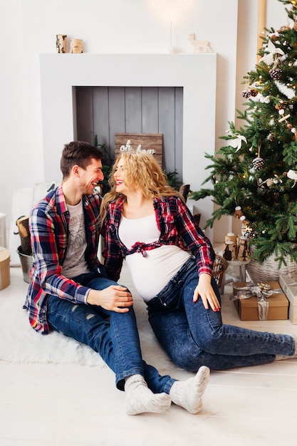 Young people will soon be parents happy against the backdrop of Christmas decorations