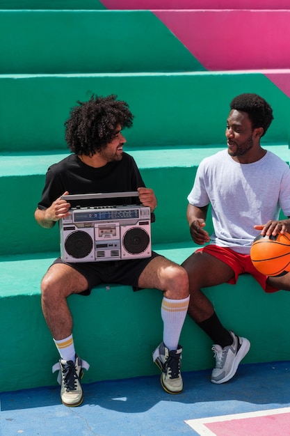Young people with afro hair listening to music on cassette