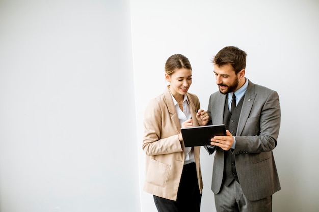 Young people with digital tablet by the wall  in the modern office