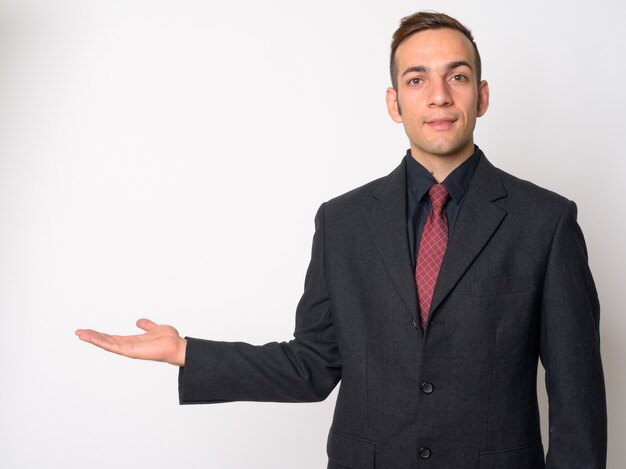  young Persian businessman wearing suit against white wall