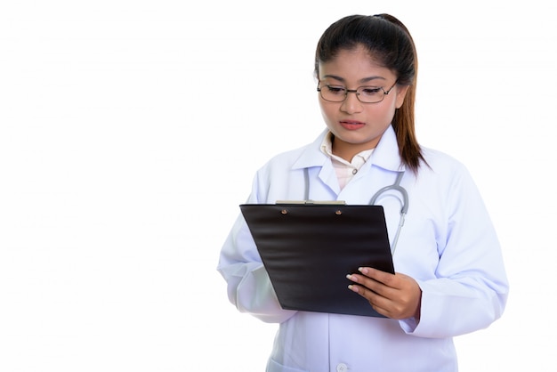 young Persian woman doctor reading on clipboard