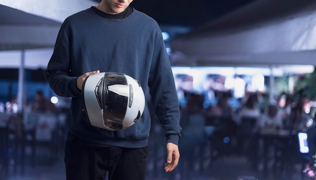 A young person holding white race helmet for motorsport