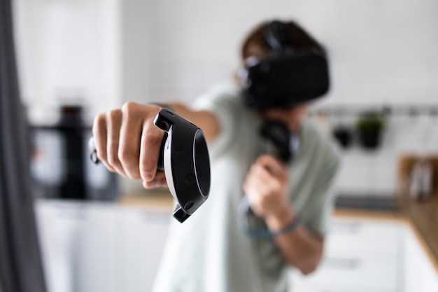 Photo young person playing videogames with vr glasses