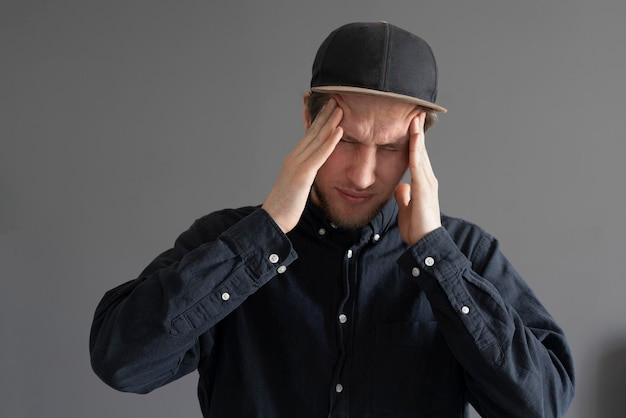 A young person touch his head feeling headache and stress