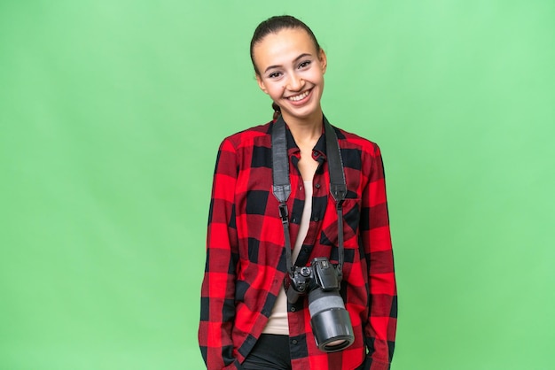 Young photographer Arab woman over isolated background laughing