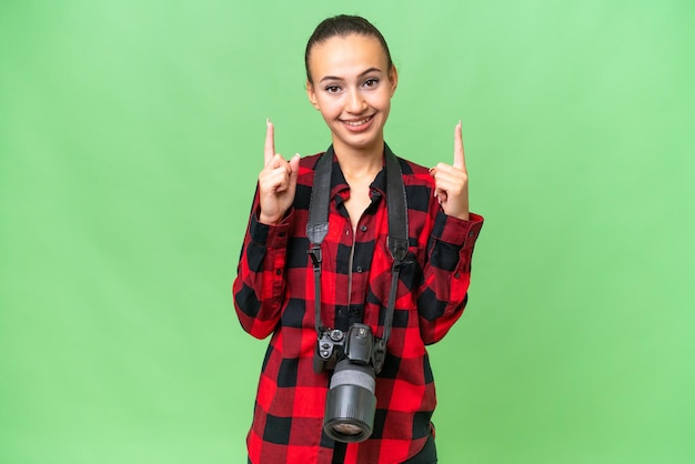 素晴らしいアイデアを指している孤立した背景の上の若い写真家アラブ女性