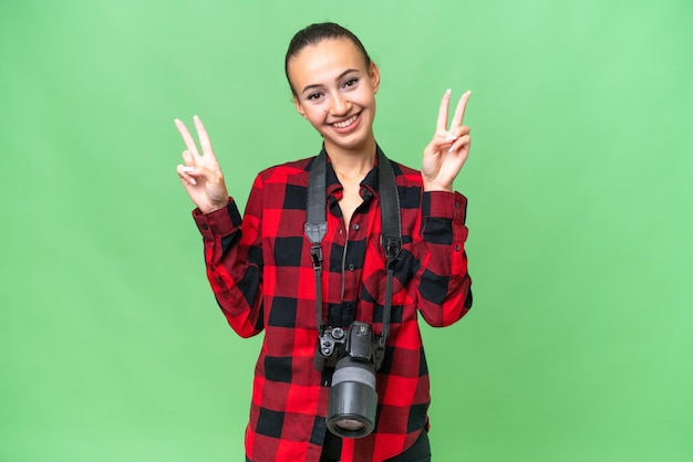 Young photographer Arab woman over isolated background showing victory sign with both hands