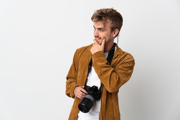 Young photographer blonde man isolated on white background looking side