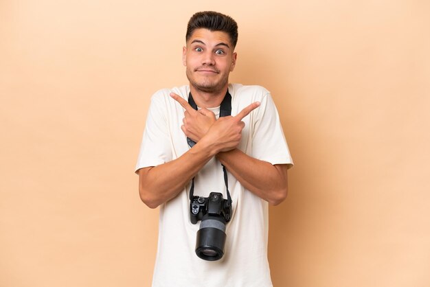 Foto giovane fotografo uomo caucasico isolato su sfondo beige che indica i laterali che hanno dubbi