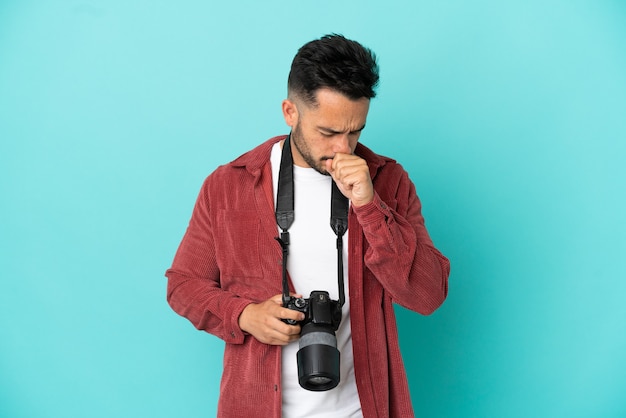 Young photographer caucasian man isolated on blue background is suffering with cough and feeling bad