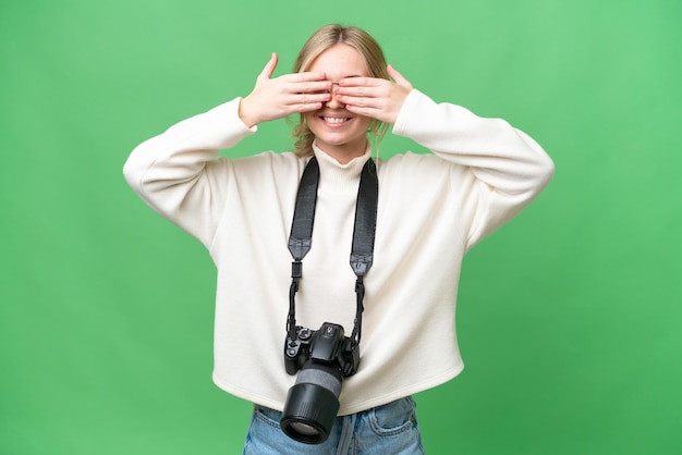 写真 手で目を覆っている孤立した背景の上の若い写真家英国女性