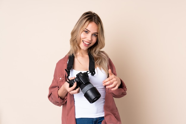 Young photographer girl over wall making guitar gesture