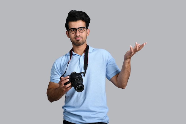 young photographer holding camera and pointing away indian pakistani model