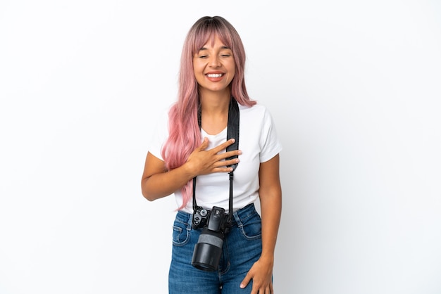 Young photographer mixed race woman with pink hair isolated on white background smiling a lot