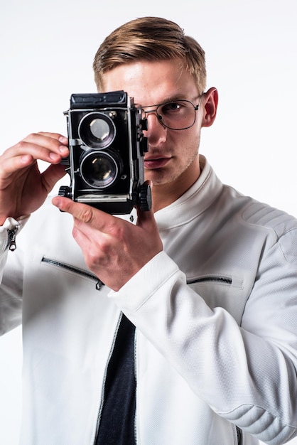 Young photographer take photograph looking in eye of retro camera isolated on white, session.