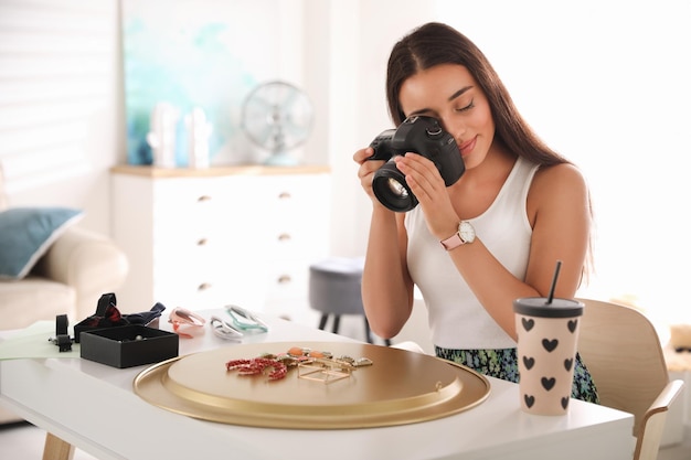 Young photographer taking picture of jewelry indoors