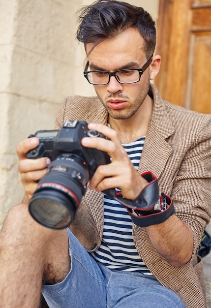 カメラで写真を見る若い写真家