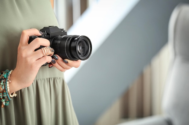 Молодой фотограф с камерой в помещении