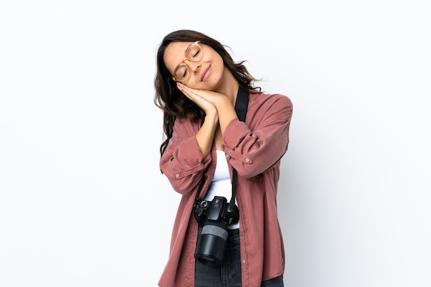 Young photographer woman over isolated white background making sleep gesture in dorable expression