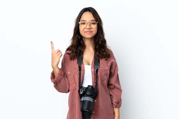 Young photographer woman over isolated white background pointing up a great idea