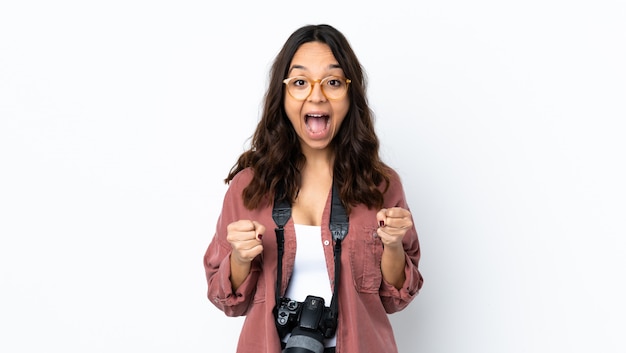 勝者の位置で勝利を祝う孤立した白の上の若い写真家女性