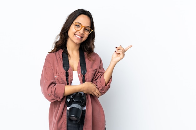 Young photographer woman over isolated white happy and pointing up