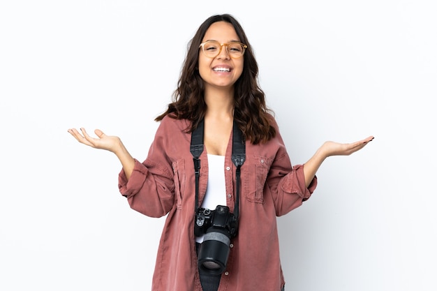 たくさん笑って孤立した白い壁の上の若い写真家の女性