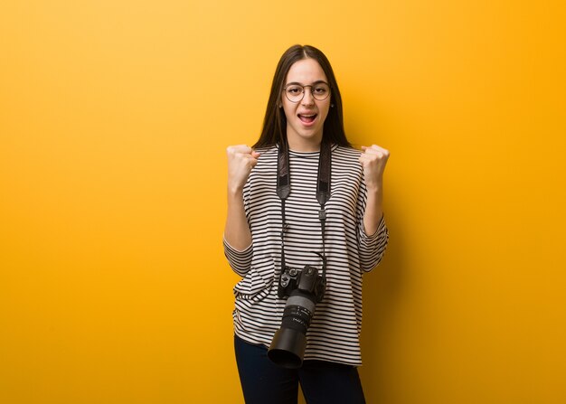 非常に怒って攻撃的な叫び声を上げる若い写真家の女性