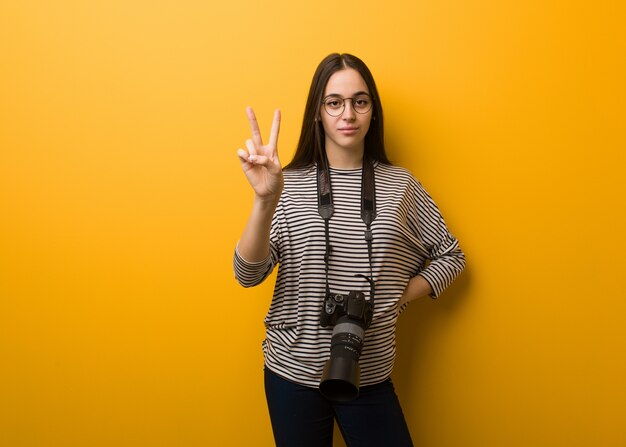 Young photographer woman showing number two