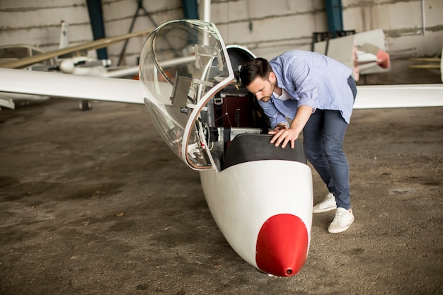 Young pilot checking airplane in the hangar