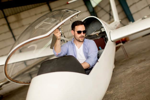 Young pilot checking airplane in the hangar