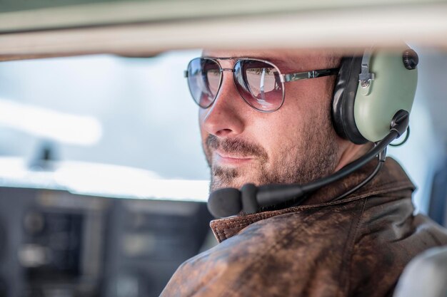 Young pilot sitting in cockpit, portrait