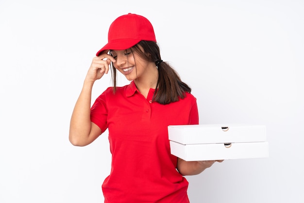 Young Pizza delivery girl over isolated white background laughing