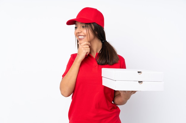 Young Pizza delivery girl over isolated white background looking to the side