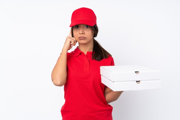 Young Pizza delivery girl over isolated white wall thinking an idea