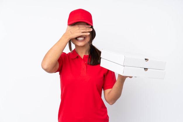 Young Pizza delivery woman over isolated white wall covering eyes by hands